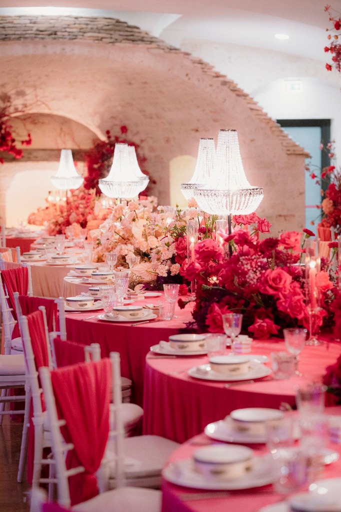 Allestimento LIPPOLIS: lungo tavolo imperiale fucsia intenso con alti candelabri di cristallo